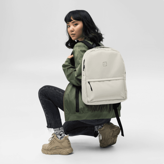 SCHWITT SHOT Black Label Ultra Premium Backpack (SS)ian Beige worn by a woman sitting