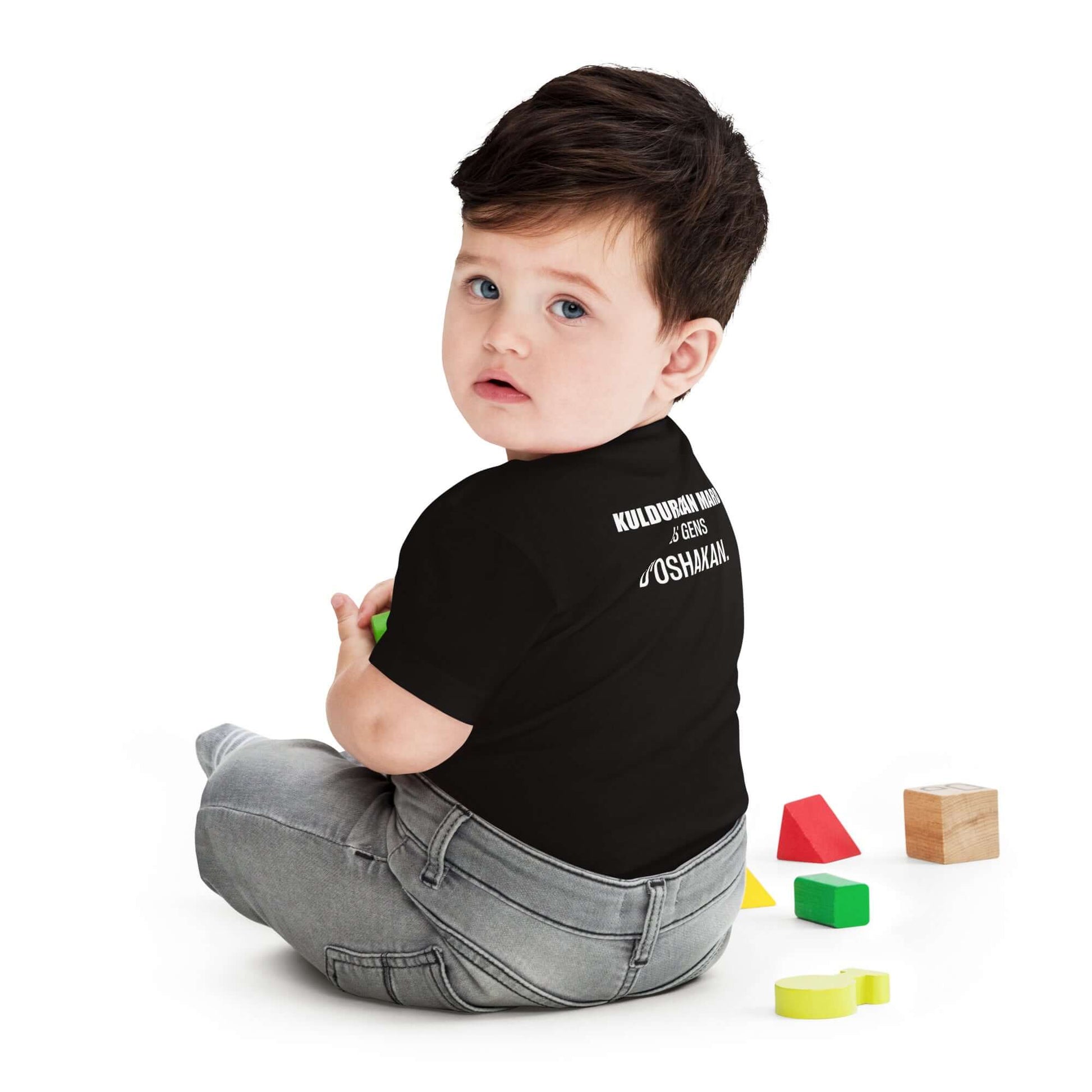 Toddler wearing KULDURAKAN MARD black t-shirt, showcasing the inscription 'Les Gens d’Oshakan' from the back.